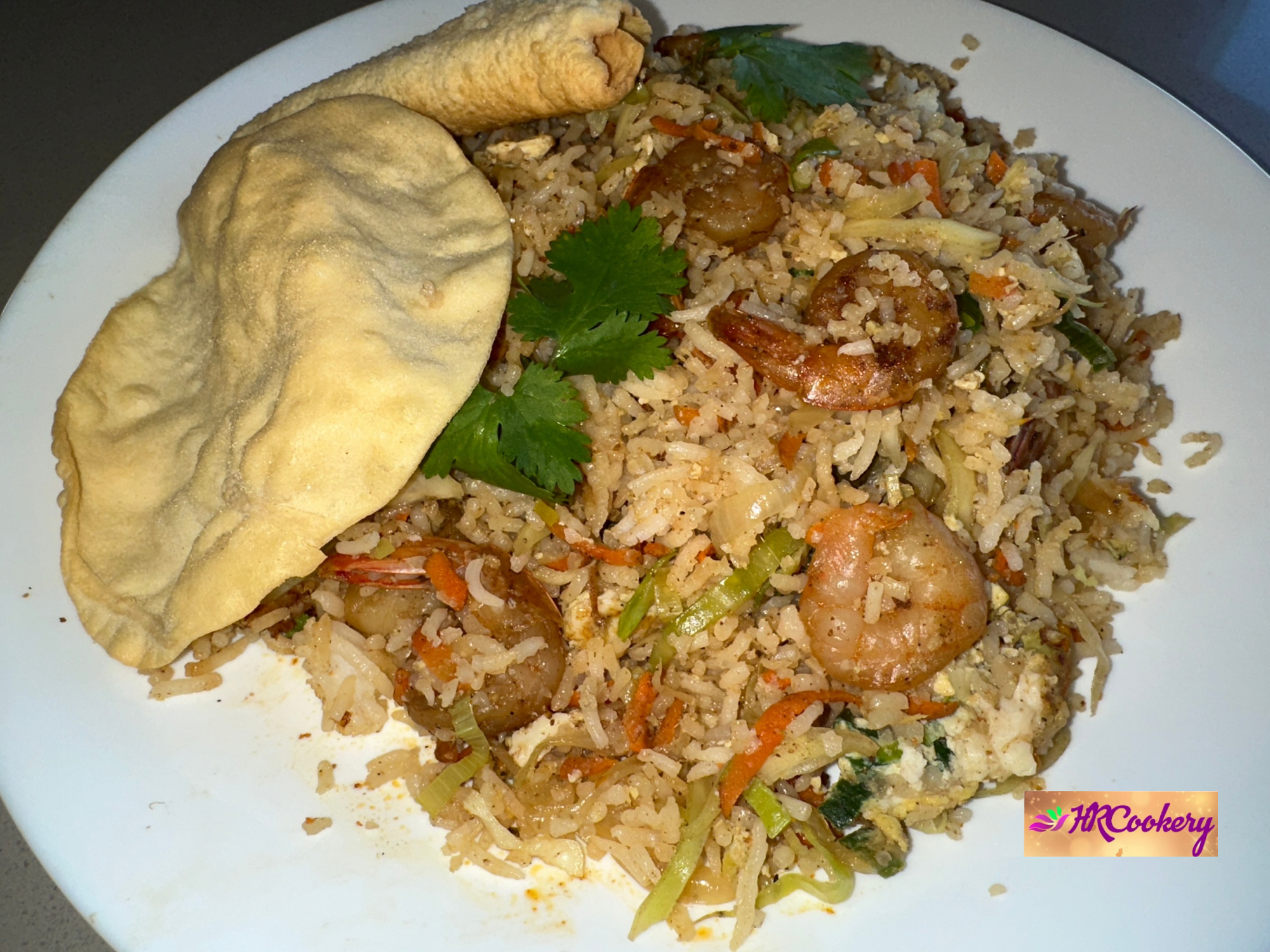 Shrimp fried rice with vegetables and scrambled eggs in a wok.