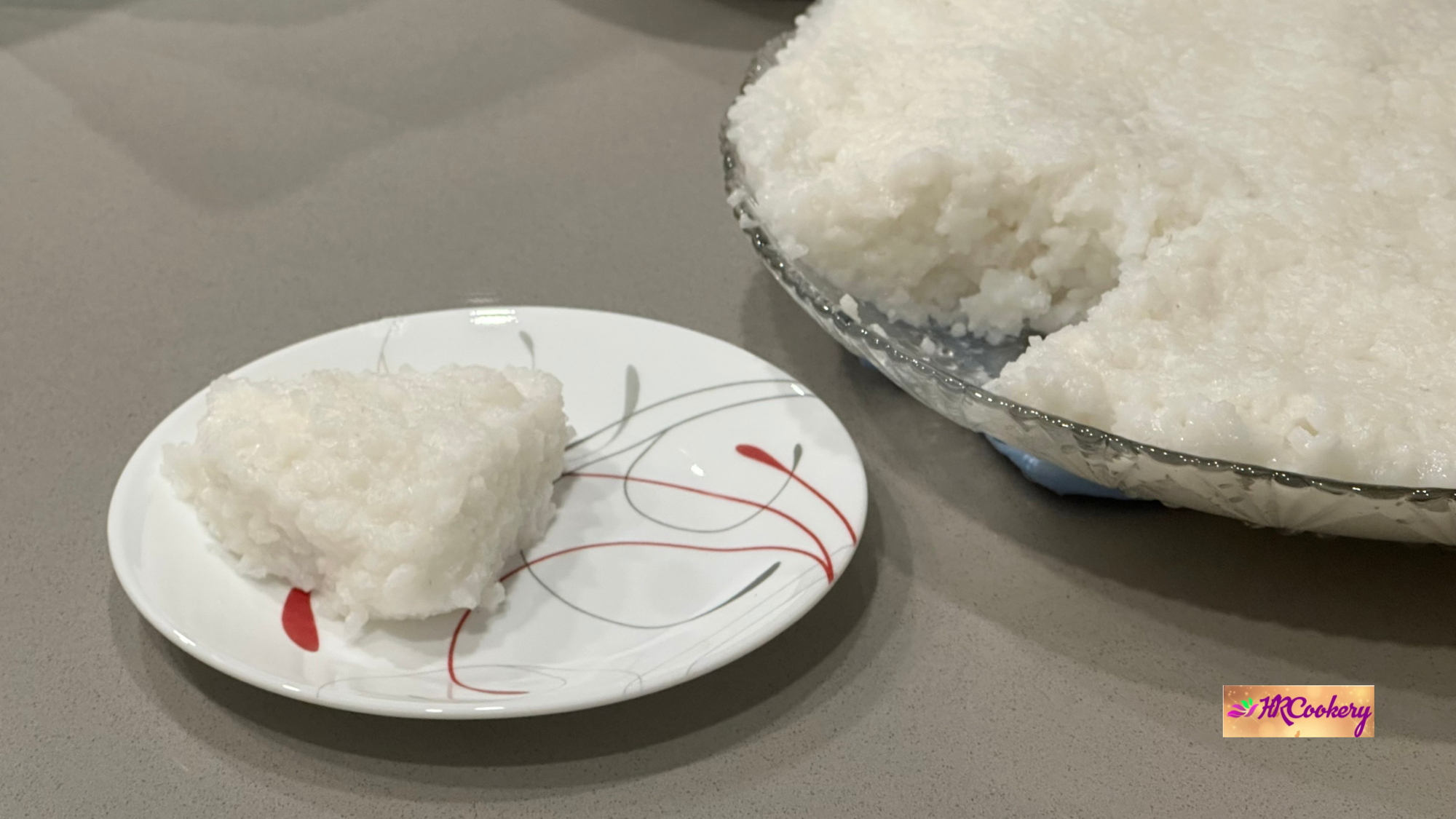 Sri Lankan milk rice (kiri bath) cut into a square piece and served on a small plate beside a glass bowl of milk rice.