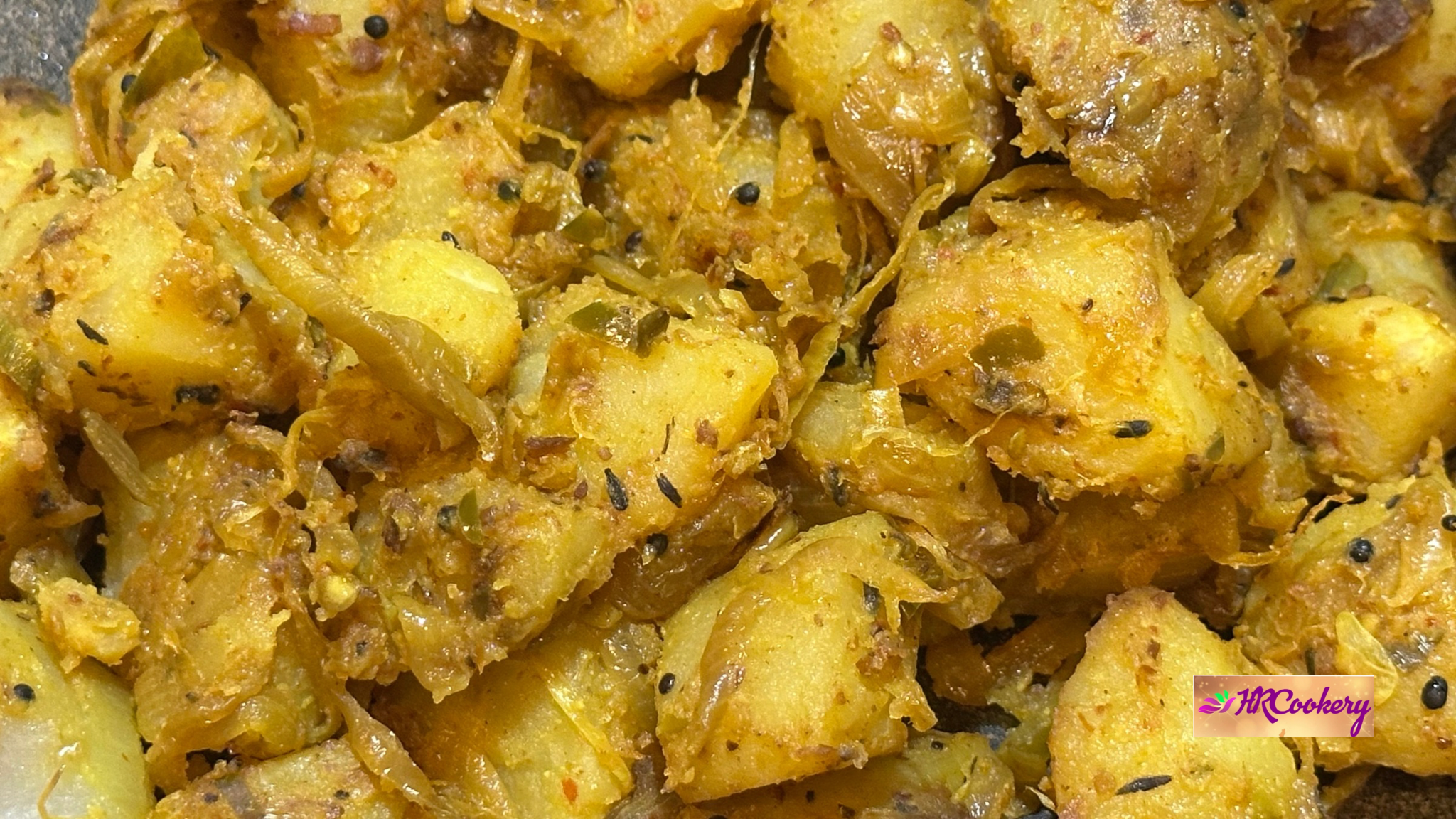 Close-up of Sri Lankan spicy potato fry with onions, curry leaves, and mustard seeds, showing crispy edges and rich golden color.