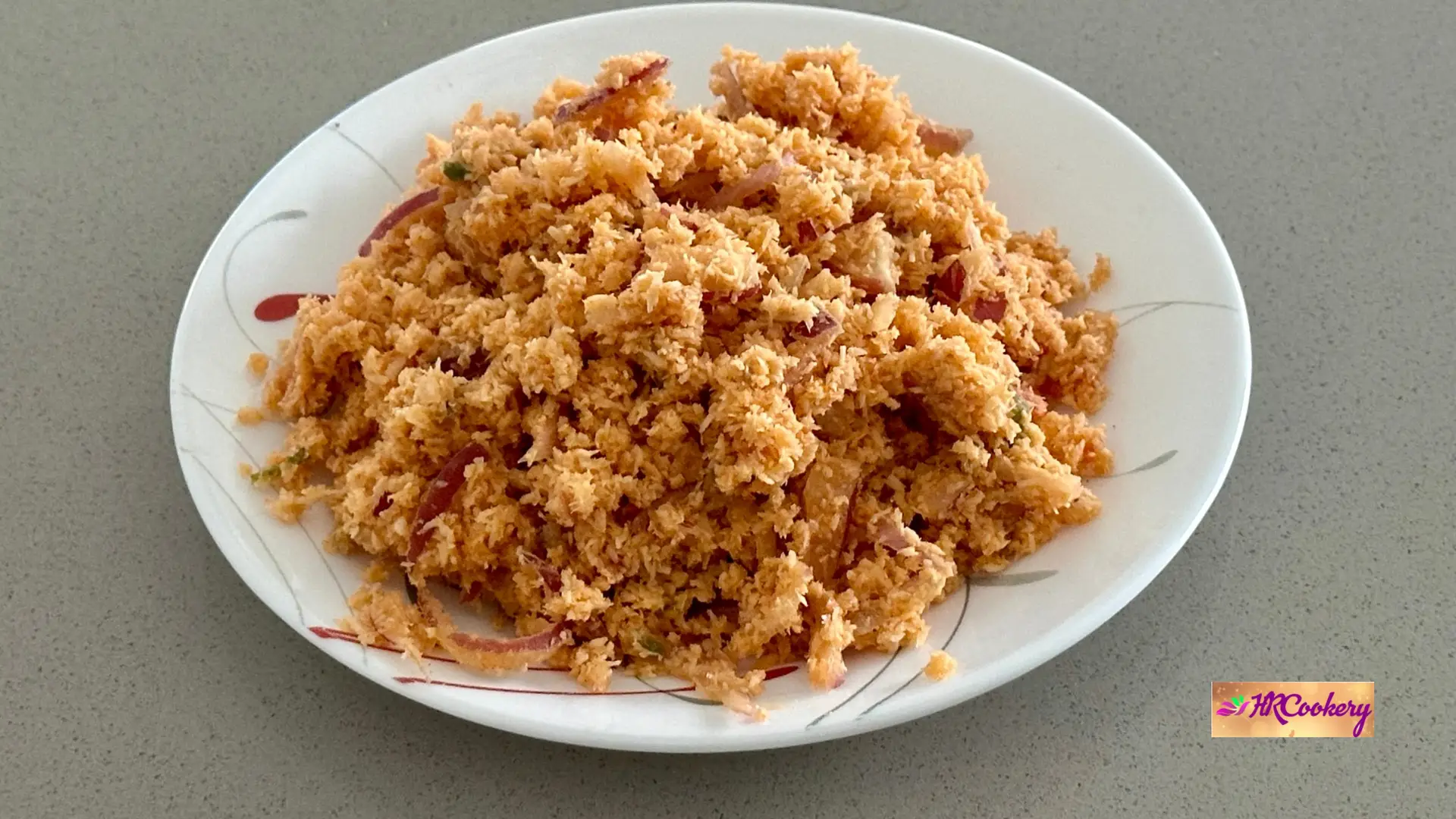 A bowl of freshly made Sri Lankan coconut sambal with grated coconut, red chilies, and onions, served as a vibrant spicy side dish.